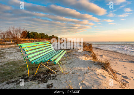 Banc en bois sur la dune de sable au coucher du soleil la lumière. La Péninsule de Hel. Pologne, Europe Banque D'Images