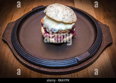 Close up on beaty hamburger sur plat marron, faite avec le pain blanc, le fromage, l'oignon et le radicchio rosso Banque D'Images
