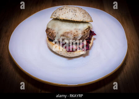 Close up sur la beauté hamburger sur le plat blanc, faite avec le pain blanc, le fromage, l'oignon et le radicchio rosso Banque D'Images