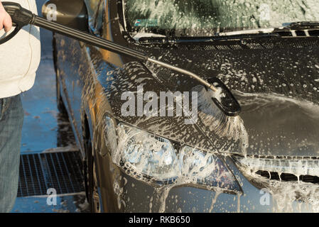 Laver la voiture à l'aide d'un pinceau dans un lavage de voiture en libre-service Banque D'Images