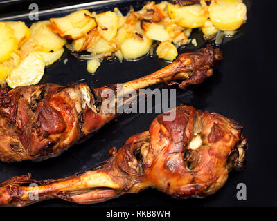 Close-up composé de deux pattes d'agneau rôti avec des pommes de terre et salade Banque D'Images