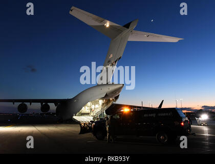 Un C-17 Globemaster III à partir de la 105e Airlift Wing à Stewart, New York prend en charge la 104e Escadre de chasse, le 8 février 2019, à la base de la Garde nationale aérienne Barnes, Massachusetts. La forme des aviateurs 104 FW coordonnée avec l'équipage d'AW 105 aviateurs obtenir en toute sécurité, qui avait été à Patrick Air Force Base, en Floride sur un droit temporaire, affectation retour à la 104e. (U.S. Photos de la Garde nationale aérienne par Airman Sara Kolinski) Banque D'Images