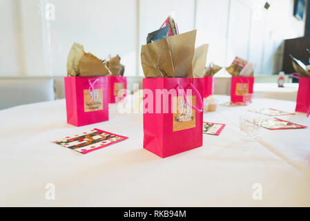 Joyeux anniversaire 30 avec un petit sac cadeau avec peluche et présente les éléments du parti. Posé sur une table blanche avec éclairage des touches haut papier farci de Banque D'Images