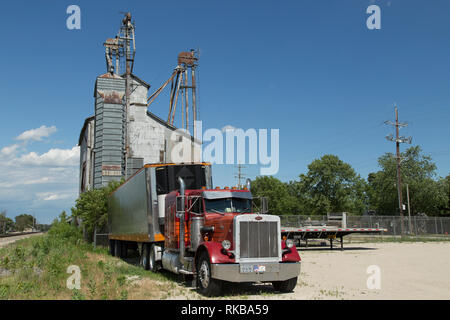 Un vieux semi-remorque se trouve ci-dessous un élévateur à grain de la ville rurale de Mazon l'Illinois. Banque D'Images