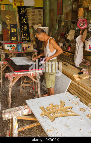 Pancarte engraver sculpter et de calligraphie glid sculptés sur les panneaux de bois pour un magasin chinois, la Malaisie Ipoh sign in Banque D'Images