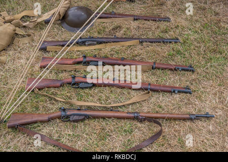 WW1 British rifles, Magazine court (Lee Enfield SMLE) lying on grass with helmet en arrière-plan Banque D'Images