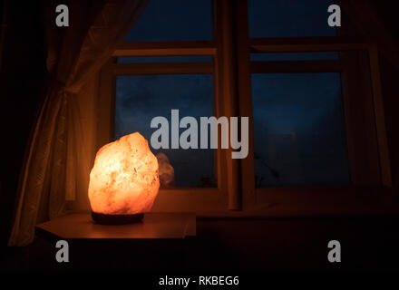 Lampe de Sel de l'himalaya décoratif activé par vieille fenêtre en bois blanc avec des rideaux en tissu filet blanc, regardant par la fenêtre des cadres en bois soleil o Banque D'Images