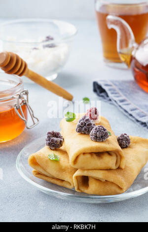 Crêpes farcies à la ricotta avec du miel, des mûres et de menthe. Banque D'Images