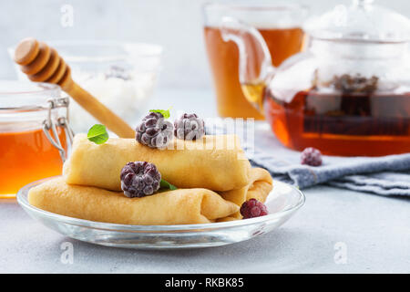 Crêpes farcies à la ricotta avec du miel, des mûres et de menthe. Banque D'Images