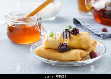 Crêpes farcies à la ricotta avec du miel, des mûres et de menthe. Banque D'Images