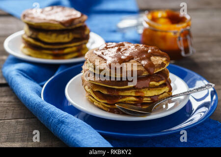 Crêpes à la citrouille avec le caramel sur fond de bois Banque D'Images