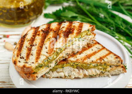 Petit déjeuner gastronomique. Sandwich avec du poisson blanc (cabillaud, Pollock, nototenia, le merlu, la perche) et sauce pesto vert (aneth, persil, oignon de printemps). Pain Banque D'Images