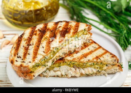 Petit déjeuner gastronomique. Sandwich avec du poisson blanc (cabillaud, Pollock, nototenia, le merlu, la perche) et sauce pesto vert (aneth, persil, oignon de printemps). Pain Banque D'Images