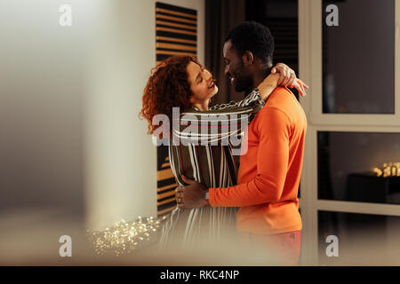Serrant ses ami afro-américain une brunette amie rouge attrayant Banque D'Images