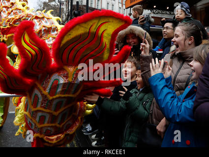 (190210) -- Londres, le 10 février 2019 (Xinhua) -- les enfants à toucher les pièces du costume de la danse du dragon les performances pendant un défilé du Nouvel An lunaire chinois à Londres, Grande-Bretagne, le 10 février, 2019. Londres a accueilli le dimanche l'une des plus grandes célébrations du Nouvel An chinois à l'extérieur de l'Asie, dessin de dizaines de milliers de visiteurs en plein cœur de la capitale britannique pour partager la joie. La célébration a commencé par un grand défilé avec 30 équipes dont une équipe de Lion et de Dragon chinois, un bus à impériale de Londres et une variété de streaming flotte dans les rues de Trafalgar Square, via Ouest fin être Banque D'Images