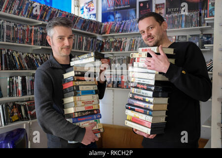 Kassel, Allemagne. 06Th Feb 2019. Ralf Stadler (l) et Christoph Langguth sont debout avec une pile de cassettes VHS en DVD avant d'étagères dans la Kassel le film. Les deux appartiennent à Randfilm, l'association qui a sauvé la boutique vidéo la plus ancienne d'Allemagne de la destruction il y a plus d'un an. Depuis la reprise par Randfilm Videothek a changé : c'est un mélange de film distribution, musée et lieu culturel. ((Dpa 'Verein macht aus Videothek Deutschlands ältester ein Museum' à partir de 11.02.2019) Crédit : Uwe Zucchi/dpa/Alamy Live News Banque D'Images