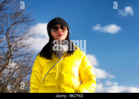 Une femme chinoise portant un blouson jaune regardant la caméra sur une froide journée d'hiver dans la région de West Stockbridge Massachusetts. Banque D'Images