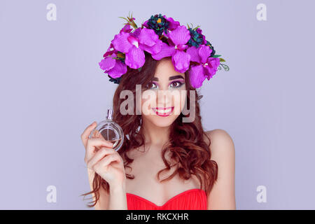 Femme avec couronne de fleurs donnant flacon de parfum Banque D'Images