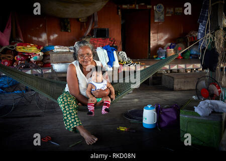 Lac Tonlé Sap, au Cambodge. 17 Décembre, 2018. Grand-mère tient son petit-enfant tout en restant assis dans un hamac à l'intérieur de leur maison flottante. Photo : Bryan Banque D'Images