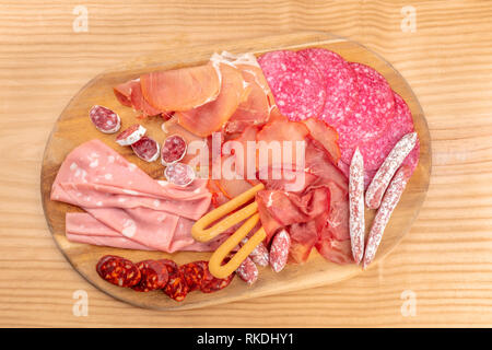 Dégustation de charcuterie. Une photo prise à la verticale d'un bac avec beaucoup des saucisses et jambons, charcuterie, tourné par le haut sur un fond rustique Banque D'Images