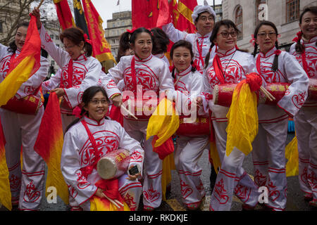 Toutes les femmes du groupe de danse chinoise en vêtements traditionnels et colorés avec des instruments de musique qui prennent part à la Parade du Nouvel An Chinois, Londres, Royaume-Uni. Banque D'Images