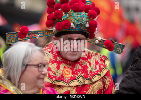 Western homme vêtu de vêtements traditionnels chinois et de la tête pour célébrer le Nouvel An chinois défilé, Trafalgar Square, Londres, Royaume-Uni. Banque D'Images