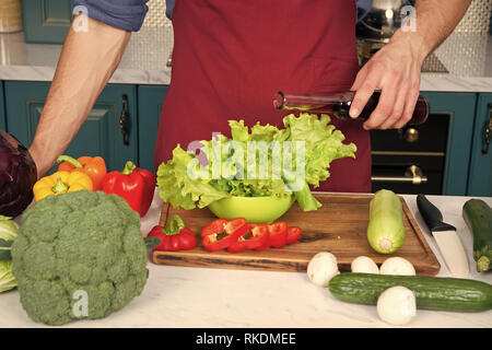 Mesurer avec précision. Rien d'épaves plat comme une double portion de vinaigre ou d'huile. Mains des hommes chef pouring laitue avec du vinaigre ou l'huile sans mesure. Les questions de mesure peut entraîner le gaspillage de produits. Banque D'Images