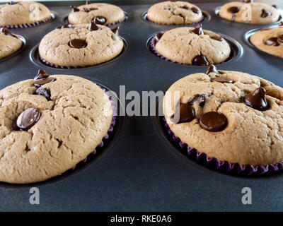 La vanille fait maison et de chocolat muffins sur un arrière-plan noir Banque D'Images