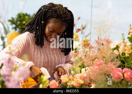 Belle brune avec des dreadlocks roses d'arrosage avec plaisir Banque D'Images