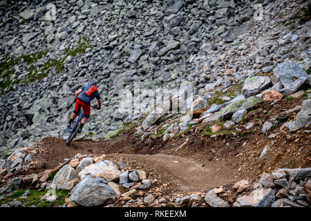 Un homme monte un vtt sur un sentier rocheux dans la station autrichienne de Sölden dans la vallée de l'Ötztal pendant les mois d'été. Banque D'Images
