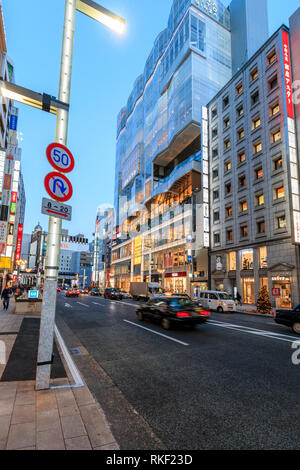 Tokyo, Ginza. Heure d'or. Afficher le long de rue avec Kirarito Ginza, high end 12 centre commercial bâtiment avec des arbres de Noël à l'extérieur sur la chaussée. Banque D'Images