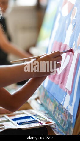 Preschool girl painting in art class. La photo en gros pinceau dans la main Banque D'Images