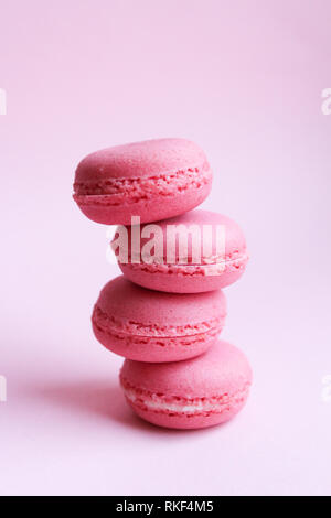 Quatre macarons rose sur un fond rose, le minimum de nourriture concept Banque D'Images