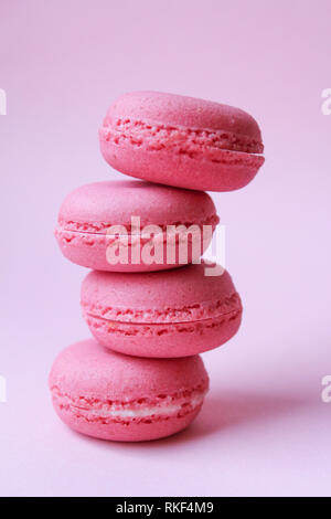 Quatre macarons rose sur un fond rose, le minimum de nourriture concept Banque D'Images