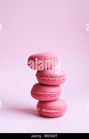 Quatre macarons rose sur un fond rose, le minimum de nourriture concept Banque D'Images