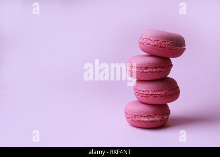 Quatre macarons rose sur un fond rose, le minimum de nourriture concept Banque D'Images