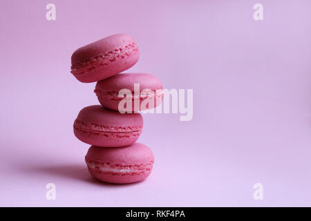 Quatre macarons rose sur un fond rose, le minimum de nourriture concept Banque D'Images