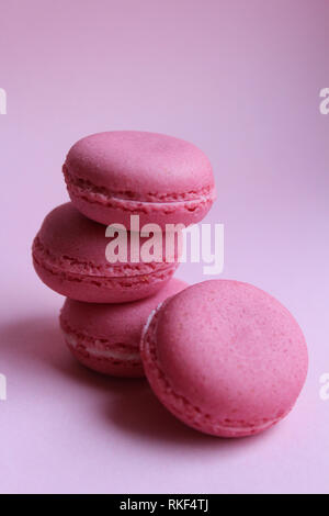 Quatre macarons rose sur un fond rose, le minimum de nourriture concept Banque D'Images