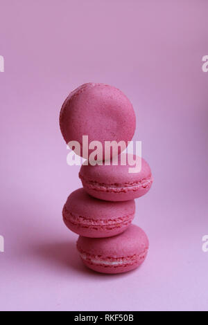 Quatre macarons rose sur un fond rose, le minimum de nourriture concept Banque D'Images