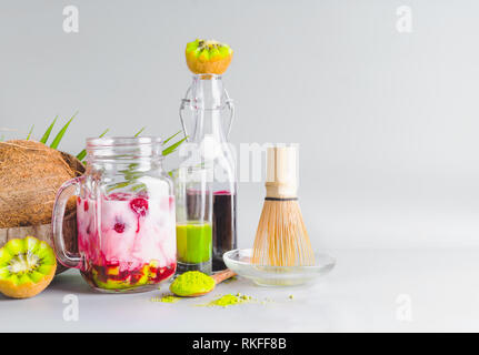 Matcha thé vert sain fusion vegan latte dans un bocal en verre avec des ingrédients sur la table. Boisson expresso Matcha avec du jus de fruits roses. Les antioxydants, detox Banque D'Images