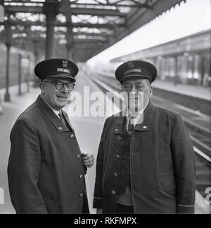 1968, photo montre deux membres du personnel en uniforme joyeuse British Rail Station, un contremaître et contrôleur debout ensemble sur la plate-forme à la gare de Blackheath, Blackheath, Londres, Angleterre, Royaume-Uni. Banque D'Images