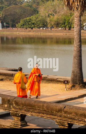 Les moines portant des robes safran, utiliser la dernière technologie sur leur téléphone mobile, Ta Prohm, Angkor Wat, Siem Reap, Cambodge Banque D'Images