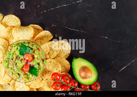 Guacamole vert avec des nachos et d'avocat sur fond de pierre Banque D'Images