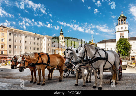 Calèches alignées prêt pour les touristes sur Residenzplatz, Salzburg, Autriche, Europe. Banque D'Images