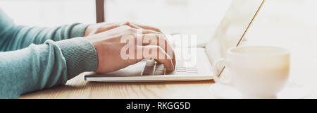 Portrait de man typing on laptop while working at home Banque D'Images