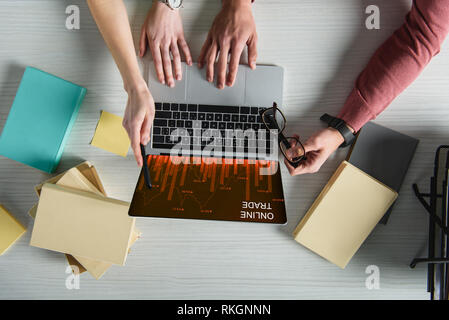 Portrait of woman pointing at laptop avec le commerce en ligne sur le site web de l'écran près de man holding glasses Banque D'Images