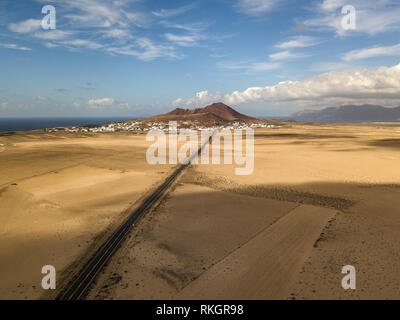 Vue aérienne d'un paysage désertique, sur l'île de Lanzarote, îles Canaries, Espagne. Route qui traverse un désert. Langue d'asphalte noir dans le désert Banque D'Images