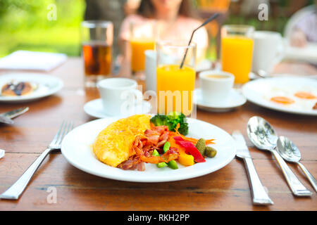 Omelette aux poivrons, concombre, bakon et salade sur la table à l'extérieur Banque D'Images