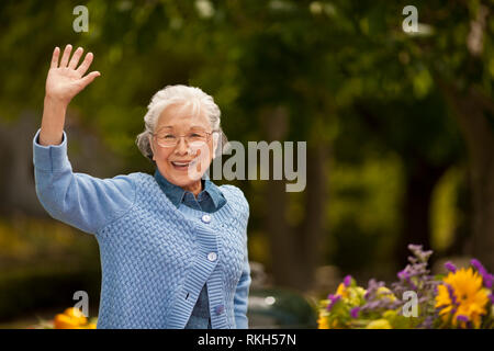 Portrait of a smiling woman waving. Banque D'Images