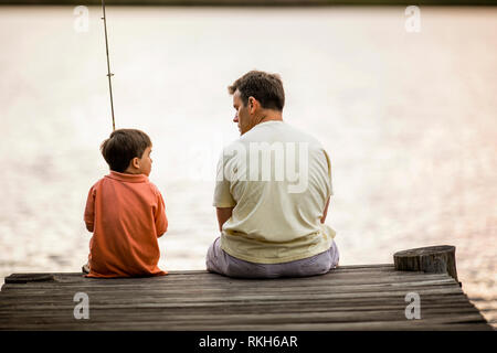 Père et fils à partir d'un quai de pêche. Banque D'Images